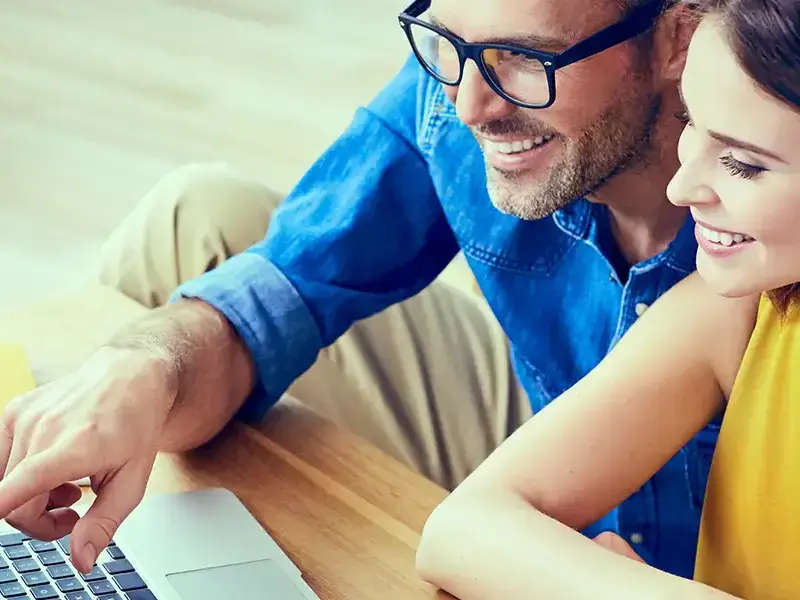 A woman and a man checking on a laptop while wmile.
